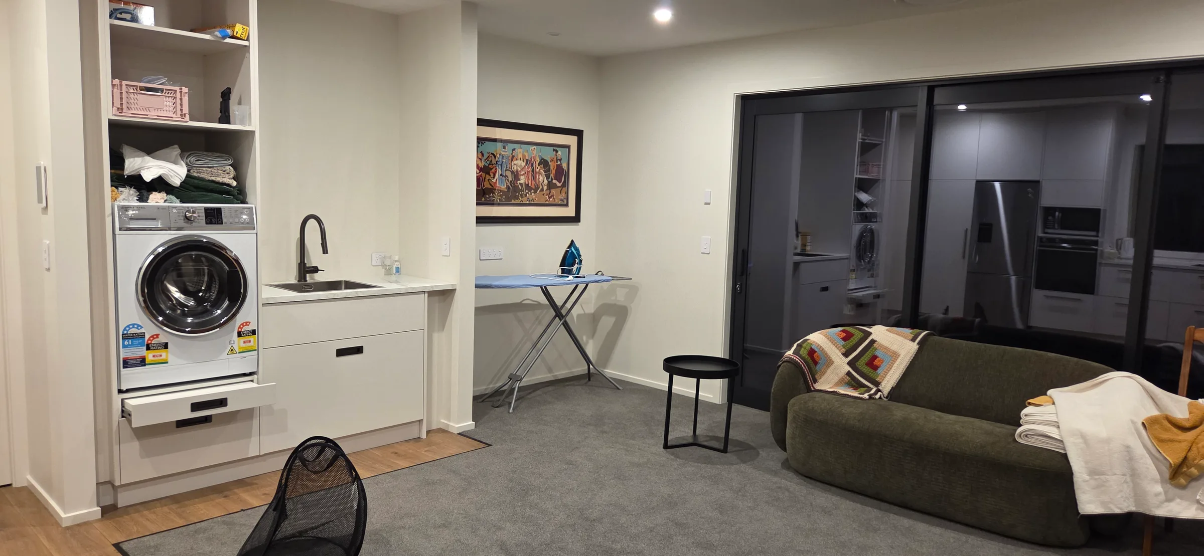 Laundry nook with washer dryer, sink and an ironing board set up